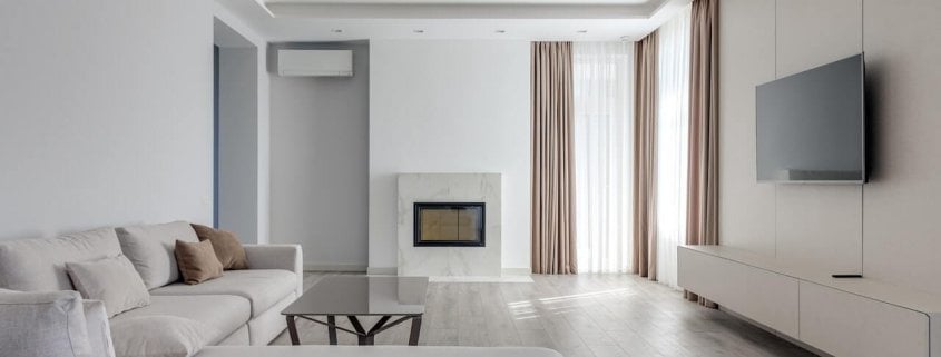 A large, white and grey colored living room with plenty of space for a whole-house humidifier.